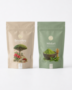 Midori Barista Matcha and Socotra Hibiscus Chai bundle. Two stand-up pouches of Ceremonial Tea from the brand Soma: a beige pouch labeled 'Socotra' with a bonsai tree and red flowers illustration, and a sage green pouch labeled 'Midori' with a bowl of green tea and bamboo whisk illustration, set against a clean white background.